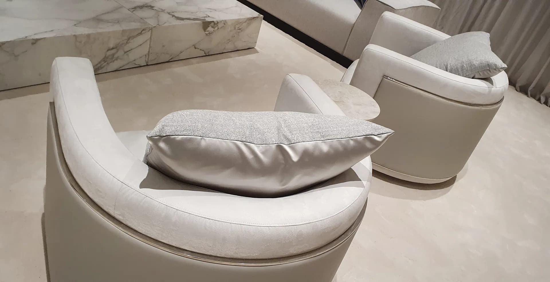 Bespoke cream leather swivel armchairs on a marble floor